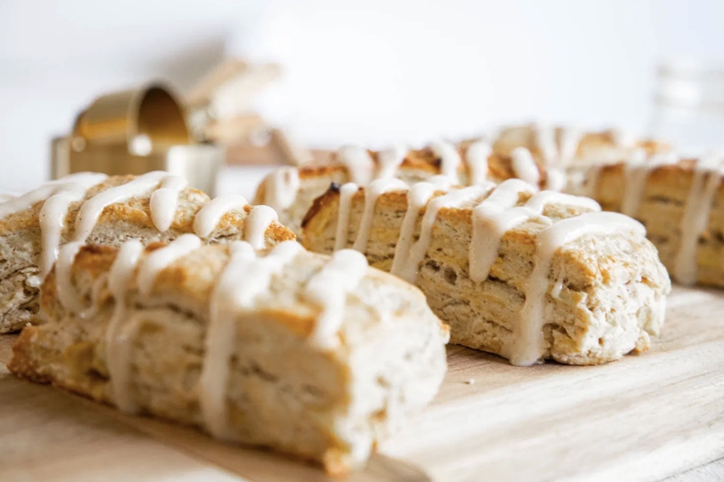 Seasonal apple and cinnamon scones made with sourdough starter discard, topped with a sweet and creaemy drizzle.