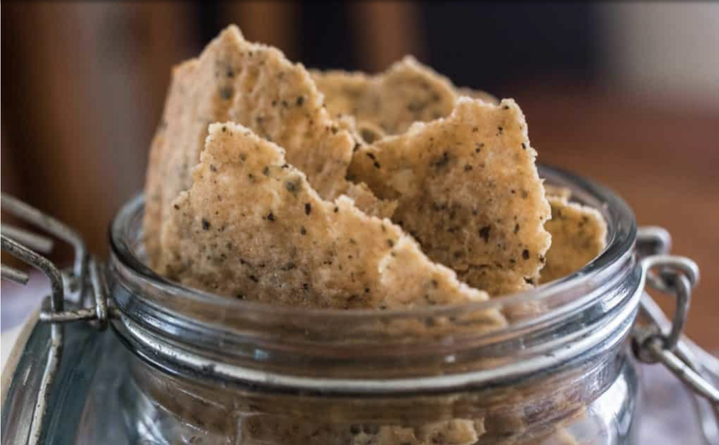 Sourdough starter discard crackers packed into a glass jar, seasoned to preference and ready to be enjoyed.