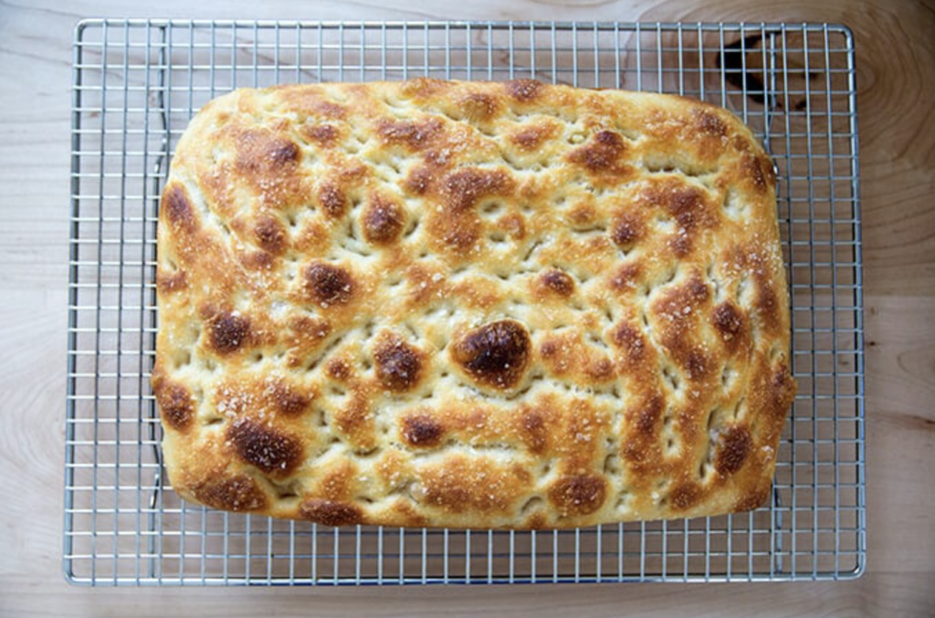 Sourdough starter discard focaccia bread sitting on a cooling wrack with no toppings, ready to be enjoyed.