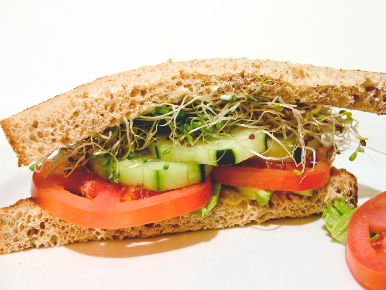 sandwich with tomatoes, cucumbers and microgreens on a white background